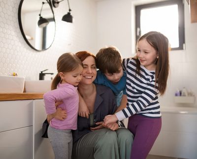 Happy family with three children in a modern bathroom — the peace of mind that comes with a Perfect Care Club plumbing membership
