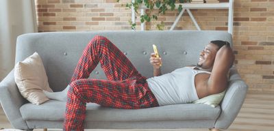 Man lying on couch using phone to request a new service area with Mr Perfect Plumbing