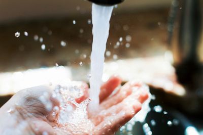 Centennial homeowner holding hand under running faucet