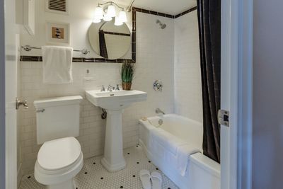 Clean residential bathroom with pedestal sink, toilet, and shower-tub combo in a Cherry Creek, Denver home
