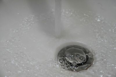 Water flowing into a bathtub drain showing need for professional drain cleaning in Cherry Creek, Denver