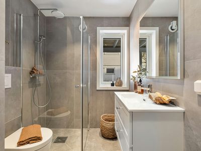Modern bathroom with glass shower enclosure and double vanity in a Cherry Creek, Denver home