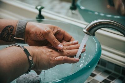 Hands washing under a modern faucet at a vessel sink in a Five Points, Denver home