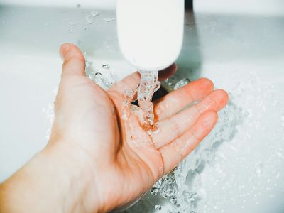 Child running their hand under bathroom sink water