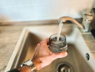 Person filling a glass of water at the kitchen faucet in a LoDo, Denver home