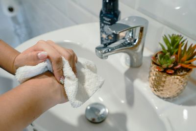 Hands drying with a towel at the bathroom sink in a LoDo, Denver home