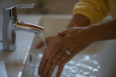 Person washing hands under bathroom sink in Lone Tree, CO home with functional plumbing
