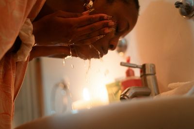 Woman washing her face at bathroom sink