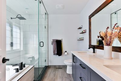 Modern bathroom with glass shower enclosure, soaking tub, and double vanity in a RiNo, Denver home