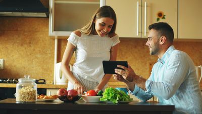 Two RiNo, Denver homeowners reviewing plumbing service options on a tablet in their kitchen